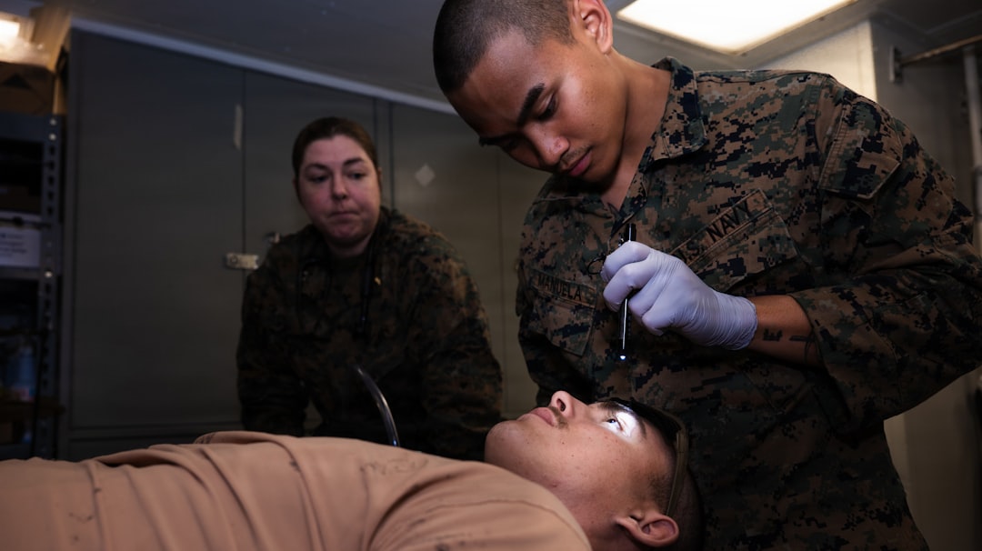 Marines practice medical procedures on a simulated patient.